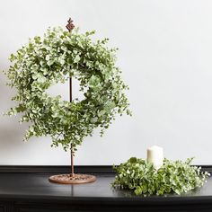 a table with a wreath on it next to a red candle