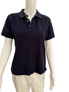 Vintage classic women's Ralph Lauren polo shirt in navy blue. Has a red Ralph Lauren monogram on the front. Green tag label. This polo has a longer back than front with a V slit at the hips. There is fading to the seam areas from wear. There are two available. One does appear to have a stain on the front and if you want that one it's only $10, but please DM me or comment in the purchase so that I can refund and send the correct one. I think the stained one could be turned into a super mini crop top for a fun Dark Academia or punk look. Cleaned and stored in a smoke-free home. Measurements  Shoulders: 16" Sleeves: 8" Bust: 38" Waist: 38" Length: 21" in front 23" in back Mini Crop Top, Navy Blue Polo Shirt, 90s Ralph Lauren, Punk Looks, Blue Polo Shirt, Ralph Lauren Polo Shirt, Ralph Lauren Polo Shirts, Blue Polo, Polo Shirt Women