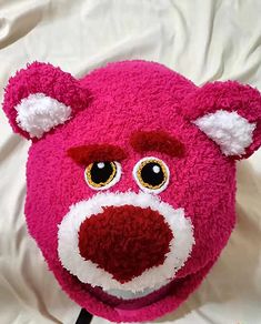 a pink teddy bear with big yellow eyes