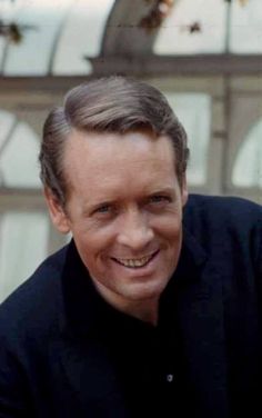 a man smiling and wearing a black shirt