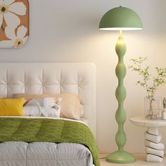 a green lamp is next to a bed in a room with a white headboard