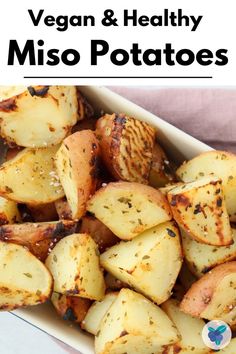 a white dish filled with seasoned potatoes on top of a pink towel and text overlay reads oil - free miso potatoes