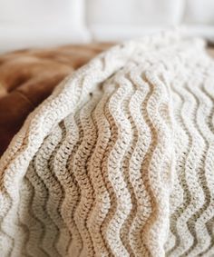 a white blanket sitting on top of a couch