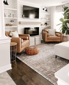 a living room filled with furniture and a flat screen tv mounted on the wall above a fireplace