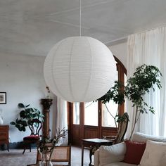 a living room filled with furniture and a large white ball hanging over the top of it