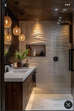 a bathroom with two sinks and lights above it