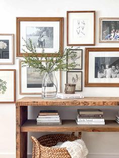 a wooden table topped with pictures and a vase filled with flowers on top of it