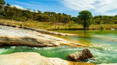 the water is green and blue with rocks in it's bottom right hand corner