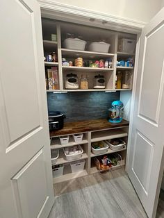 an open pantry with white cabinets and drawers