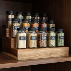 a wooden shelf filled with lots of different types of spices on top of each other