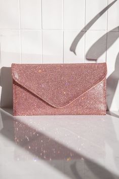 Not to be dramatic, but everyone needs this clutch! The Quentin Pink Rhinestone Envelope Purse features a pink rhinestone and vegan leather fabric, a light pink satin lining, a pink vegan leather back, a silver detachable shoulder chain, a snap button closure, and an inside card holder. Lined.;  Purse measures 9" wide, 5" tall, and 1" deep;  Man made materials.; Pink Crystal Embellished Evening Bag For Formal Events, Pink Crystal Embellished Evening Bag For Formal Occasions, Pink Rhinestone Clutch For Events, Luxury Pink Rhinestone Evening Bag, Pink Rhinestone Clutch For Evening, Pink Crystal Embellished Party Evening Bag, Luxury Pink Evening Bag With Rhinestones, Pink Embellished Evening Bag For Party, Pink Embellished Party Evening Bag