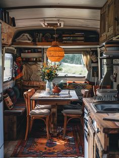 a kitchen area with a table, stove and sink inside of a camper van