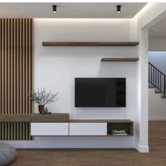 a modern living room with white walls and wood accents, including a flat screen tv