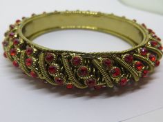 Vintage bold stunning fire opal orange red stones boldly set all around this large gold eye catching bangle bracelet. It is weighty and very well made. It measures 5/8 of an inch in width and the stonework design measures 1/2 of an inch in depth. The opening of the bangle measures 2 5/8 inches in diameter. It is in excellent condition and is an attention getter for certain. The stones are the color of fire opal which is a bright orange red color. Very unique. Please feel free to send any questions or concerns.  Your satisfaction is of utmost importance to me and I always try to treat others as I wish to be treated. If for any reason you are not satisfied with your purchase, I do offer a full refund. I will do my best to address your concerns before, during, and after your purchase. Thank y Colors Of Fire, Red Stones, The Bangles, Gold Eyes, Gold Bangle Bracelet, Gold Bangle, Red Stone, Gold Bangles, Bright Orange