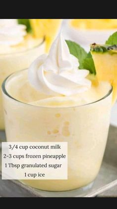 two cups filled with ice cream and topped with whipped cream, pineapple slices and mint