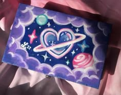 a painting on a sheet that looks like it is in the sky with stars and planets