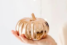 a person holding a gold pumpkin shaped object