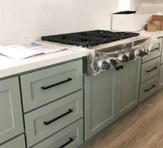 the kitchen cabinets are being installed in preparation to be painted gray and white with black handles