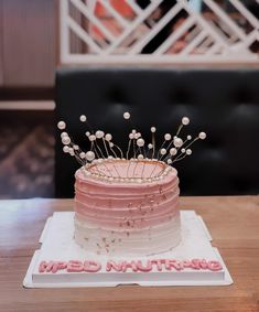 a pink cake sitting on top of a wooden table