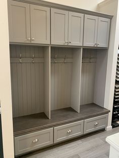 an empty room with several gray cabinets and wine bottles on the wall in front of it