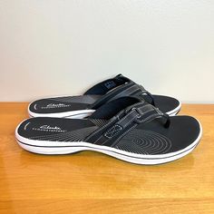 Clarks Women's Breeze Sea Black Slip On Sandals. Women's Size 12 Regular / Medium Width. Condition: New In Box; Box Has Wear. New To Poshmark? Sign Up Using Invite Code: Tentoday For $10 Off Your Purchase! Make Choosing The Perfect Flip-Flop A Breeze. These Sandals Offer A Classic Shape With Intricate Modern Detailing, Like An Oh-So-Subtle Strap Closure. Lightweight Is Key When Beach-Strolling And The Sole Construction Feels Like The Next Best Thing To Barefoot This Summer. - Subtle Closure On T Adjustable Black Slip-on Sandals, Black Synthetic Toe Post Sandals, Black Toe Post Synthetic Sandals, Black Flat Sandals With Arch Support, Black Toe Post Sandals With Arch Support, Adjustable Black Flip Flops With Buckle, Black Flip Flops With Buckle Closure For Vacation, Black Round Toe Flip Flops With Buckle Closure, Black Open Toe Flip Flops With Buckle Closure