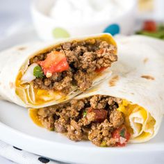 two burritos with meat and vegetables on a plate