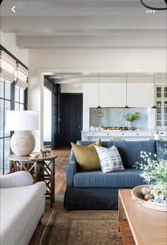 a living room filled with furniture and a wooden table in front of a blue couch