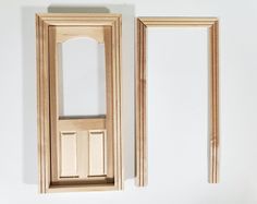 two wooden frames sitting next to each other on a white wall with one missing the door