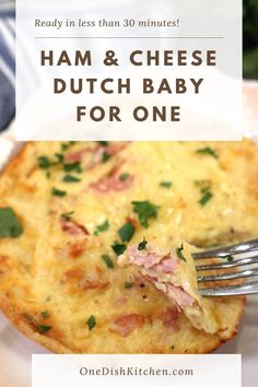 ham and cheese dutch baby for one on a white plate with a fork in it