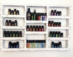 an old white shelf filled with lots of different types of essential oils and other items