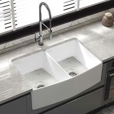 two white sinks sitting on top of a kitchen counter next to a faucet