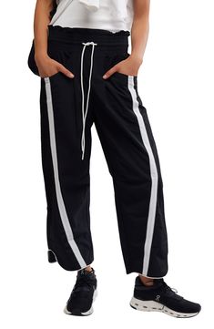 Traditionally sporty track attire gets a street-style reset in these water-resistant nylon pants refreshed with an ultrawide smocked waistband and wavy cropped hems. 25 1/2" inseam; 18" leg opening; 14" front rise; 18" back rise (size Medium) Smocked/drawstring waist Front scoop pockets; back patch pockets Water resistant 100% nylon Machine wash, tumble dry Imported Nylon Pants, Fp Movement, Free Fabric, Bottoms Pants, Track Pants, Drawstring Waist, Black Pants, Womens Bottoms, Free People