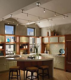 a kitchen with wooden cabinets and stools next to a center island in the middle