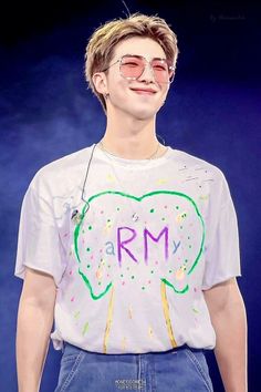 a young man wearing glasses and a t - shirt with the word rm on it