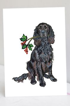 a card with a black cocker spaniel holding a holly berry in it's mouth