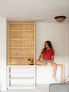 a woman sitting on top of a wooden desk