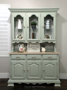 an old china cabinet painted green with white trim