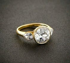 a gold ring with two diamonds on it