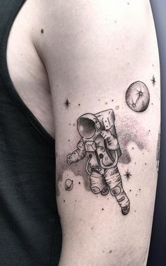 an astronaut tattoo on the right arm