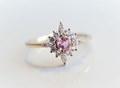 Skylar - Pink Sapphire solid 14k gold with 0.2 ct Diamond, White Sapphire or CZ, Pink Sapphire Halo Cluster Ring, Sapphire Engagement Ring by EmiConnerJewelry on Etsy https://www.etsy.com/listing/607513019/skylar-pink-sapphire-solid-14k-gold-with Pink Cluster Rings With Brilliant Cut, Pink Cluster Diamond Ring With Center Stone, Pink Cluster Ring With Brilliant Cut, Pink Brilliant Cut Cluster Ring, Pink Cluster Diamond Ring, Pink Cluster Diamond Ring Fine Jewelry, Pink Cluster Ring With Round Cut, Pink Brilliant Cut Cluster Ring For Wedding, Elegant Pink Cluster Ring For Wedding