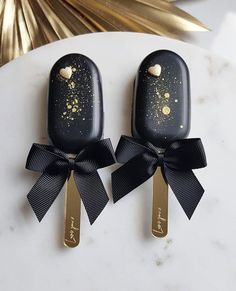 two black and gold spoons with hearts on them