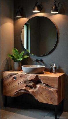 a bathroom with a round mirror above the sink and a wooden counter top below it