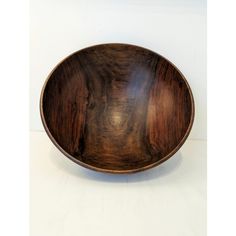 a wooden bowl sitting on top of a white table