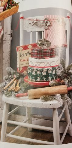 an open magazine with christmas items on the table and in front of it is a cat sleeping on top of a stack of stockings