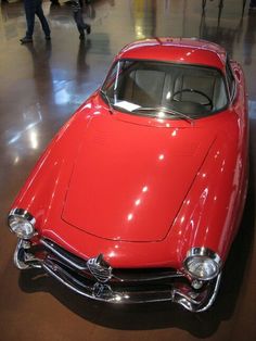 an old red car on display in a museum