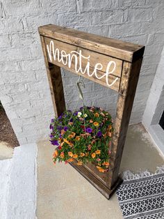 a wooden sign that says montefe with flowers in the center and hanging on it's side