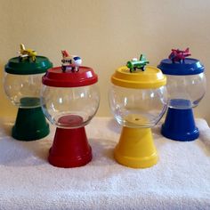 four plastic toys are sitting on top of a white towel in front of a wall