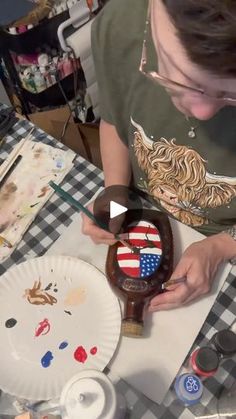 a woman is working on an american flag vase