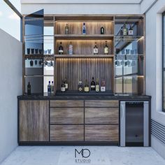 an empty bar with liquor bottles on the shelves and cupboards behind it, in front of a window