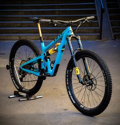 a blue mountain bike parked in front of some stairs